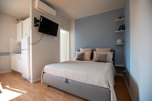 um quarto com uma cama e uma televisão na parede em LULLABY HOUSE LAZISE em Lazise
