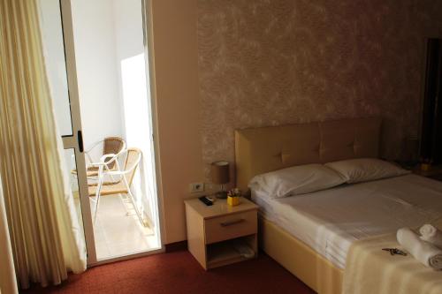 a bedroom with a bed and a table with a chair at Signature Idea hotel in Tirana