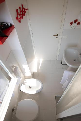 a white bathroom with a toilet and a sink at LULLABY HOUSE LAZISE in Lazise