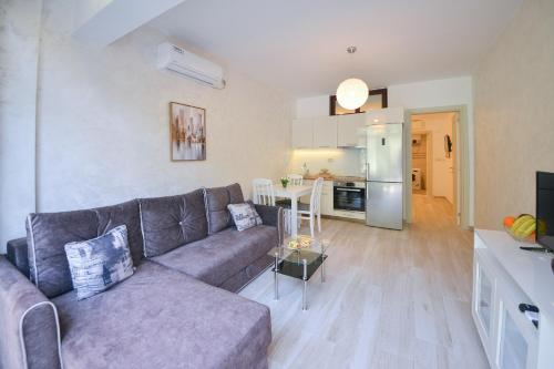 a living room with a couch and a kitchen at Brand New Apartments - free parking in Sveti Stefan