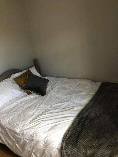un letto bianco con un cuscino nero sopra di Castle View a Listowel