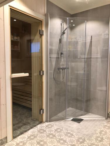 La salle de bains est pourvue d'une cabine de douche avec une porte en verre. dans l'établissement Charming Lakeside House, à Lillehammer