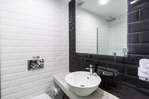 a white bathroom with a sink and a mirror at Olia Green Residence in Skopelos Town
