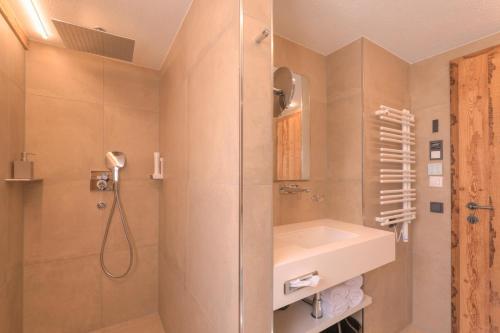 a bathroom with a shower and a sink at ArlBerglife Ferienresort in Pettneu am Arlberg