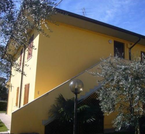 a yellow building with a street light in front of it at LULLABY HOUSE LAZISE in Lazise