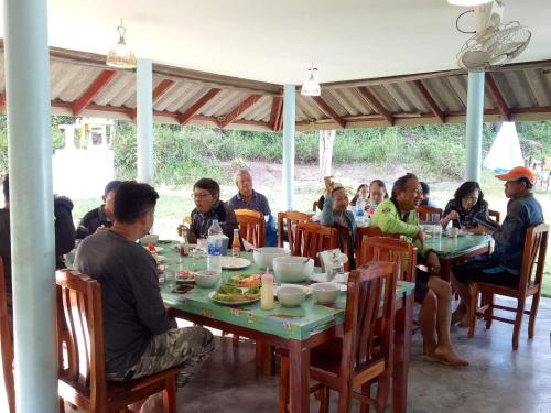 a group of people sitting at a table eating at TA YAI HOMESTAY (ตา ยาย โฮมสเตย์) in Ko Kood