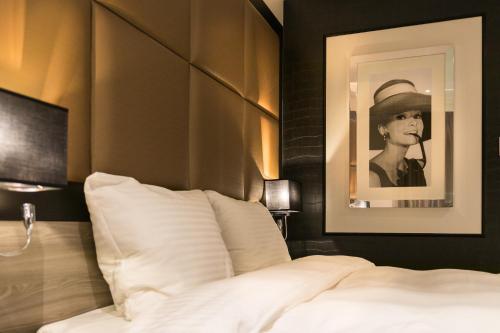 a bedroom with a bed with a picture of a woman at Riva hotel Den Haag - Delft in The Hague