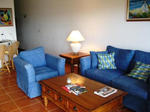 a living room with two blue chairs and a coffee table at Ocean Terrace Condominiums in The Valley