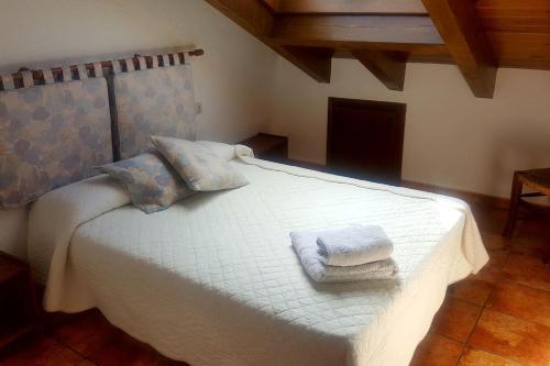 a bedroom with a white bed with towels on it at Les Forques de'n Pep in Toses
