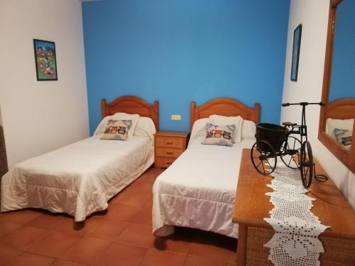 two beds in a room with blue walls at Casa Da Pallota in Moraña