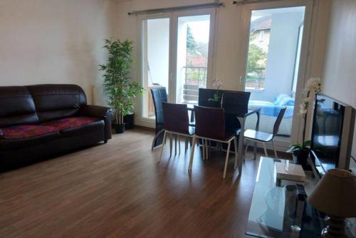 un salon avec un canapé, une table et des chaises dans l'établissement Boissy Gare RER A Appartement 1 à 3 chambres au choix, à Boissy-Saint-Léger