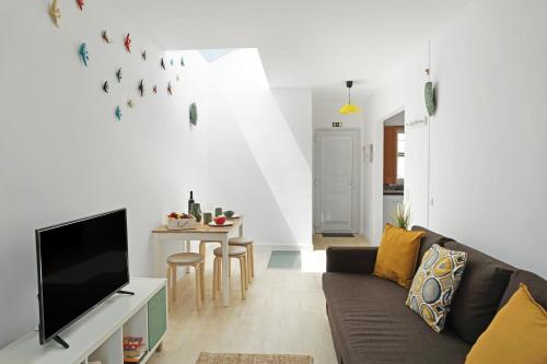 a living room with a couch and a tv at Mood Lodging Caldas & Ocean in Óbidos