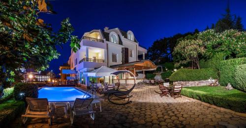 a house with a swimming pool in front of it at Milennia Family Hotel in Sunny Beach