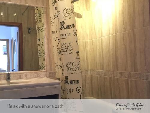 un bagno con doccia o vasca con scritta sulla tenda della doccia di Edificio Solmar Apartment ad Armação de Pêra