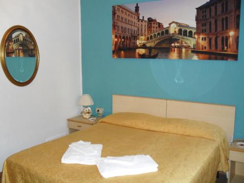a bedroom with a bed and a painting on the wall at Albergo Malibu in Sanremo