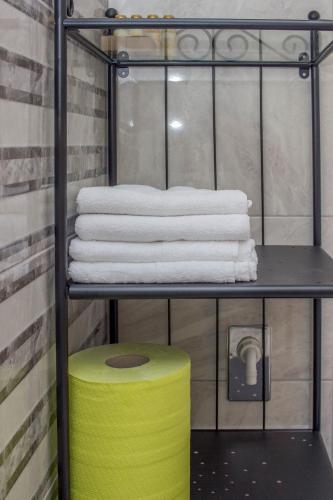 a towel rack with towels and a stack of towels at City Break Apartment in Visoko