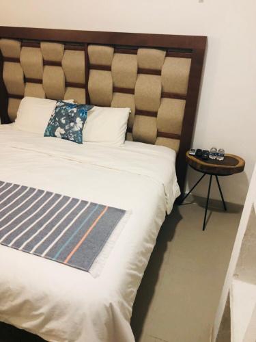 a bedroom with a large bed and a side table at Casa Bizu in Bacalar