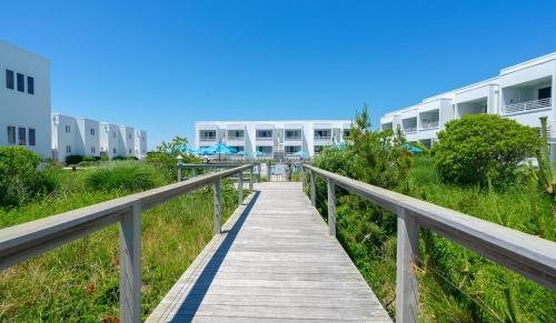 a wooden boardwalk leading to a building at The Hermitage at Napeague in Amagansett