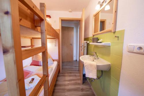 a small bathroom with a sink and a bunk bed at Haus Talblick in Ramsau