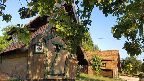 an old wooden house with windows and a tree at Les CASAS La Champrenière in Le Boupère