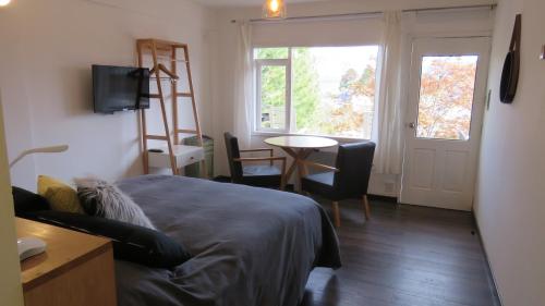 a bedroom with a bed and a table and a window at Apart Costanera in Villa Pehuenia
