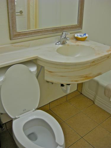 a bathroom with a white toilet and a sink at Americas Best Value Inn - Pendleton in Pendleton