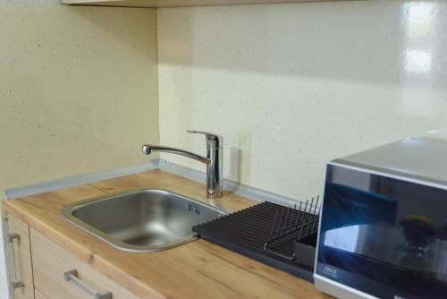 a kitchen counter with a sink and a microwave at City Center Apartments in Strumica