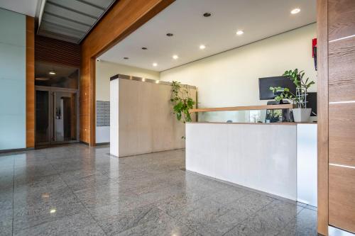 an office lobby with a reception counter and plants at Dworzec Gdański Apartament in Warsaw