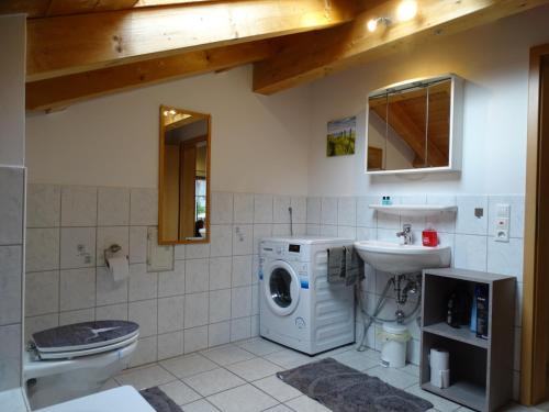 a bathroom with a washing machine and a sink at Ferienwohnung Frieda in Inzell