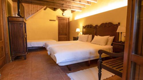 a bedroom with a bed and a bench in it at Casa do Merlo in Barreiros