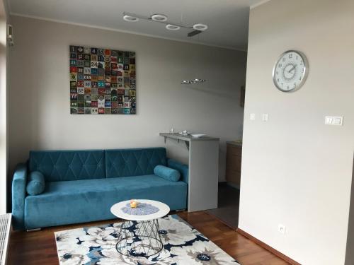 a living room with a blue couch and a table at Dworzec Gdański Apartament in Warsaw