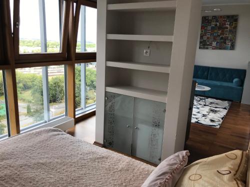 een slaapkamer met een bed in een kamer met ramen bij Dworzec Gdański Apartament in Warschau
