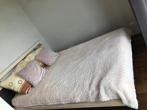 a small bed with two pillows and a blanket at Dworzec Gdański Apartament in Warsaw