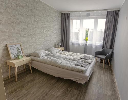1 dormitorio con cama y pared de ladrillo en Apartament dwupokojowy Poznań- blisko centrum, en Poznan