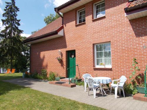 a brick house with a table and chairs in front of it at Drei Häuser in Sołtmany