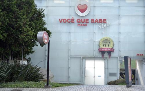 Um edifício branco com um sinal de venda de vosa. em Motel Você Que Sabe (Adult Only) em Curitiba