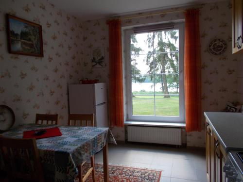 a kitchen with a table and a large window at Drei Häuser in Sołtmany