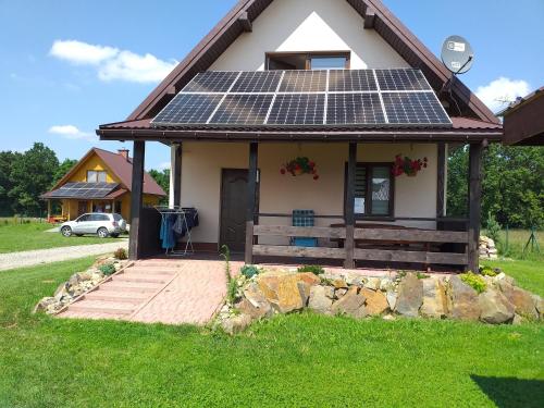 una casa con paneles solares en el techo en Domki całoroczne Bieszczady Panasiewiczówka en Odrzechowa