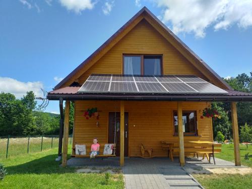 Domki całoroczne Bieszczady Panasiewiczówka في Odrzechowa: منزل على السطح مع لوحات شمسية