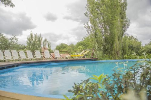una gran piscina con sillas y una mesa en El Cimarron Casa de Campo en La Granja
