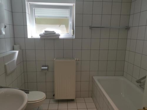 a bathroom with a tub and a toilet and a window at Ferienwohnung Bella in Koblenz