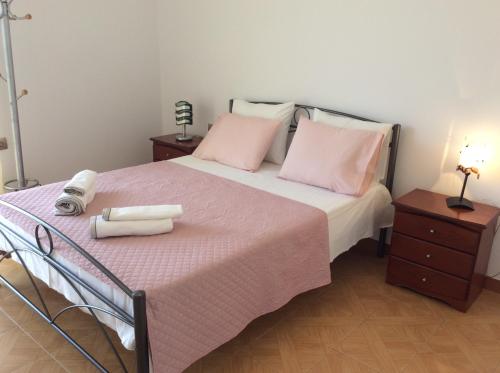 - une chambre avec un lit doté de draps et d'oreillers roses dans l'établissement Comfort Apartment in Preveza, à Prévéza