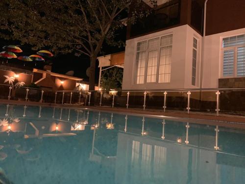 a swimming pool with lights next to a house at Qafqaz Fountain Villa in Gabala