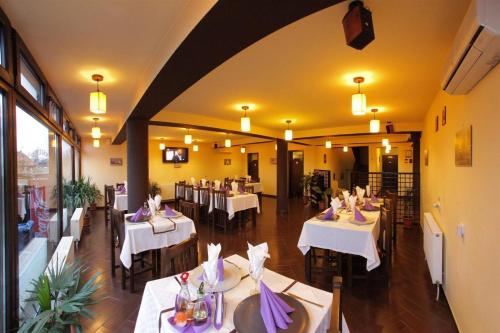 a dining room with white tables and chairs at Pensiunea Oficial in Prejmer