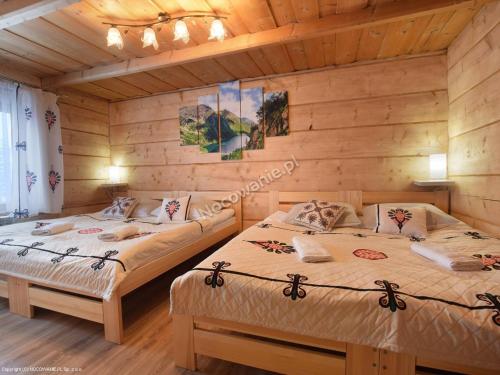 a bedroom with two beds in a log cabin at Góralski domek in Ząb