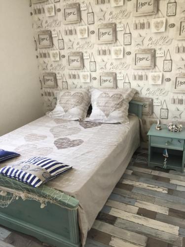 a bedroom with a bed and a wall with pictures at maison proche du Mont Saint Michel in Pontorson