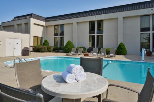 a table with towels on it next to a pool at Greenstay Hotel & Suites Central in Springfield