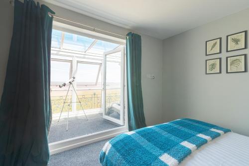 a bedroom with a bed and a large window at Marina Beach House in Caister-on-Sea