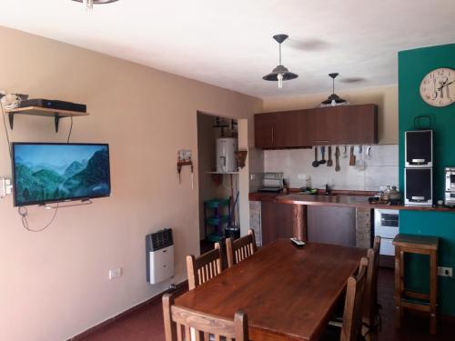 a kitchen with a table and a television on the wall at Terrazas de mayu in Villa Icho Cruz