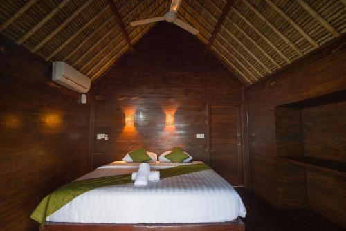 a bedroom with a bed with two towels on it at Twilight Ceningan in Nusa Lembongan
